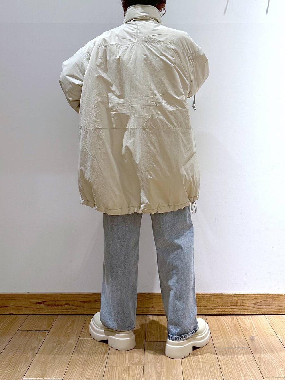 ホワイト系のダウンジャケット/コート、ブルー系のデニムパンツ、ホワイト系のブーツを着用したレディースの冬コーディネートの4枚目の写真