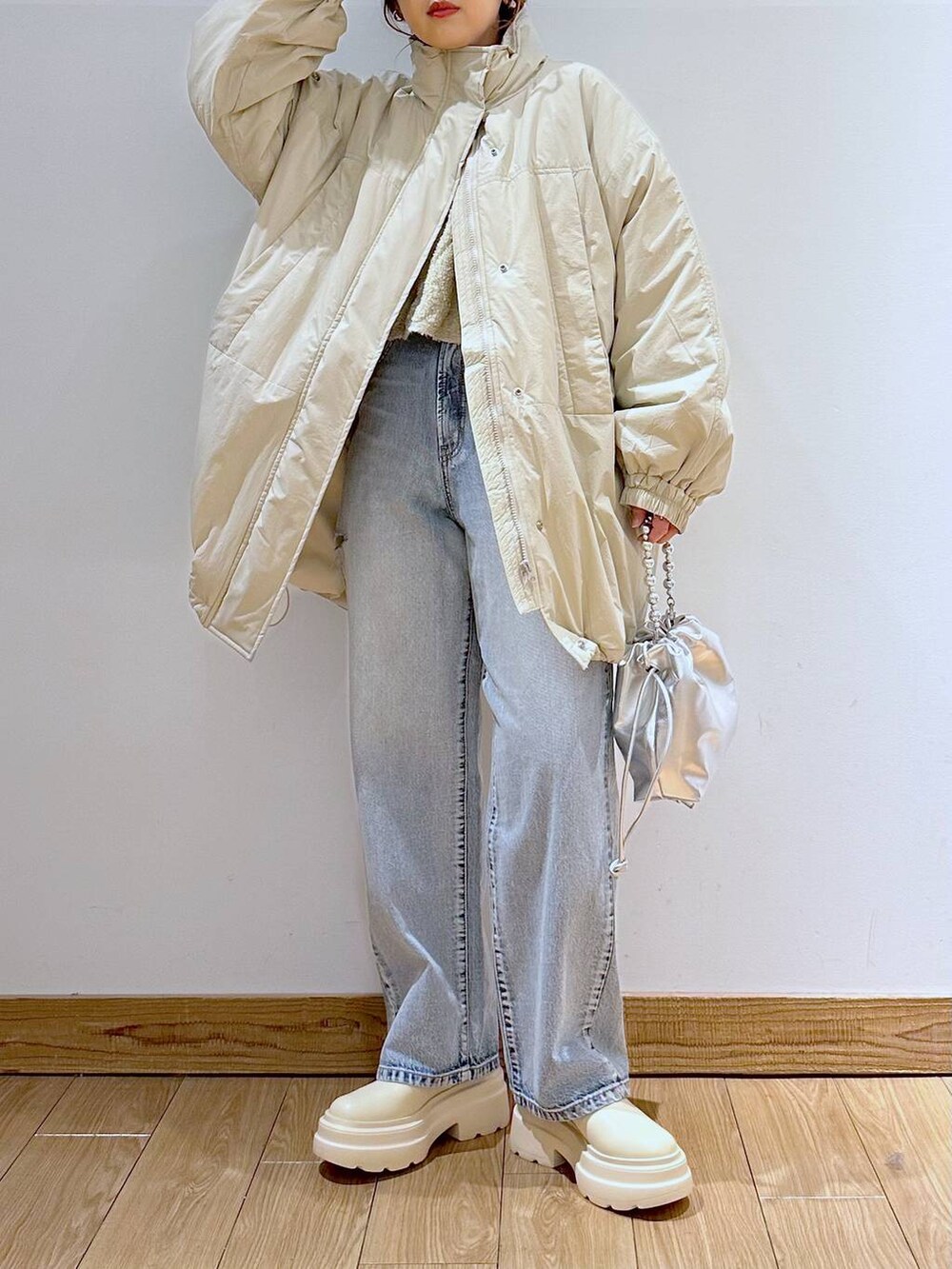 ホワイト系のダウンジャケット/コート、ブルー系のデニムパンツ、ホワイト系のブーツを着用したレディースの冬コーディネートの5枚目の写真