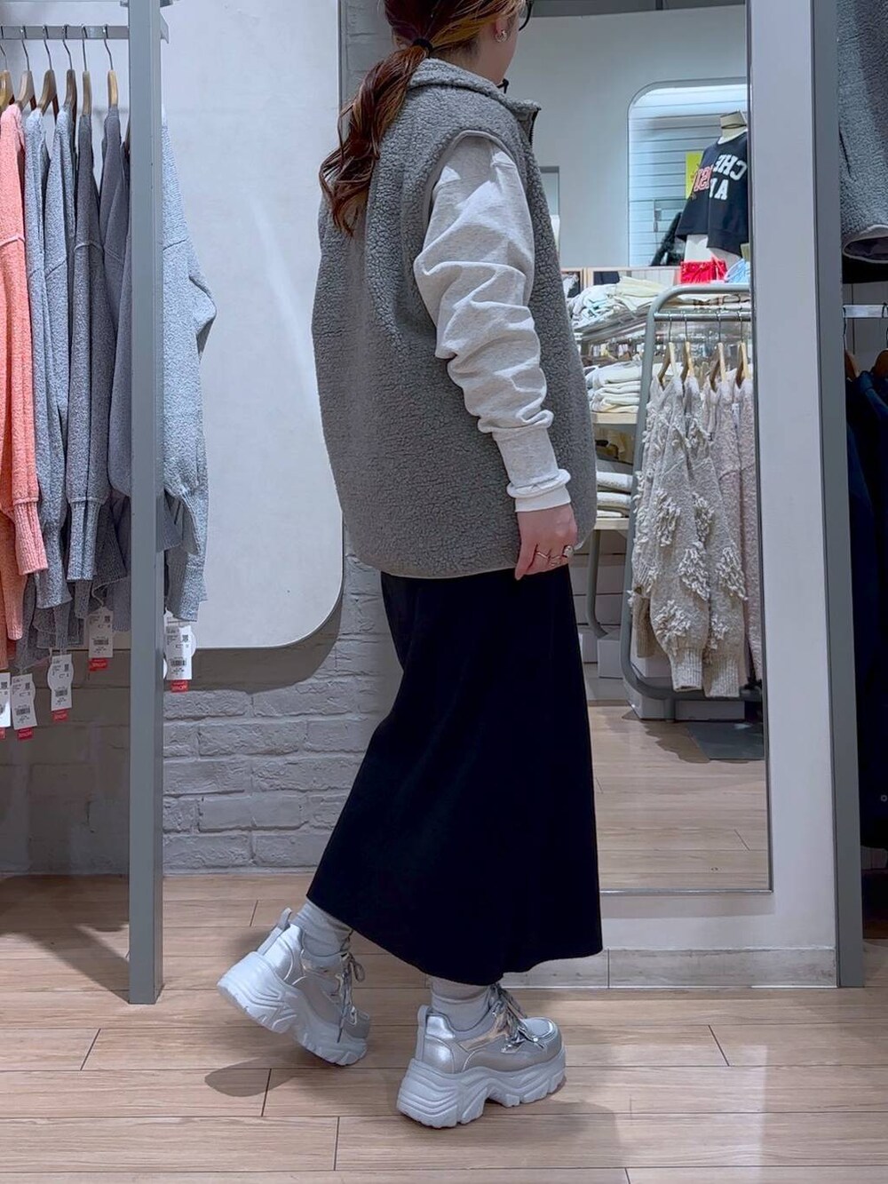 ブラック系のスカート、ブラック系のショルダーバッグ、シルバー系のスニーカーを着用したレディースの冬コーディネートの7枚目の写真