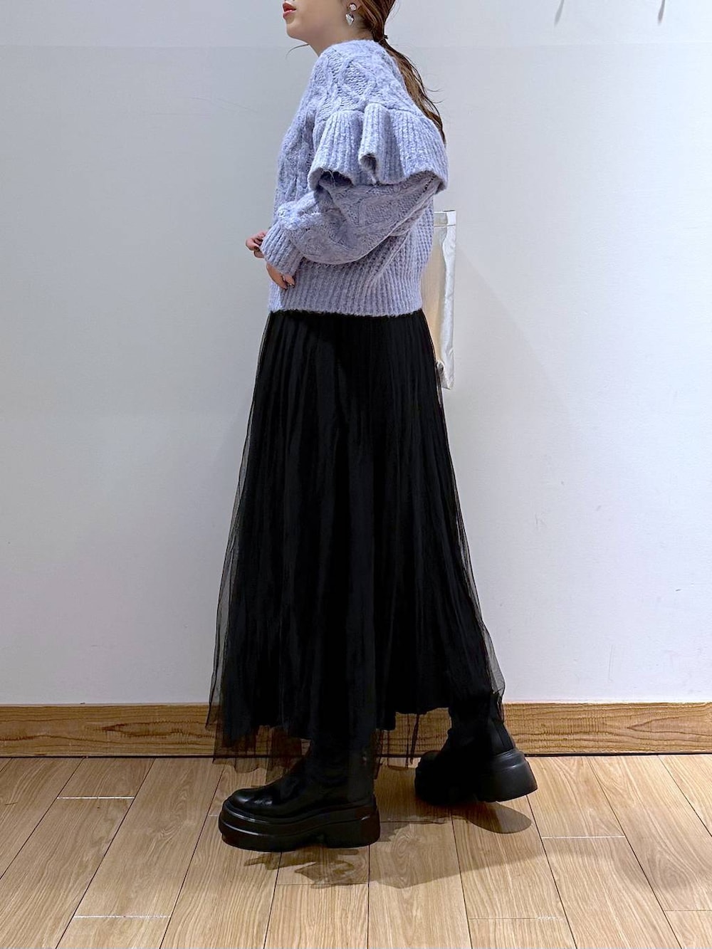 シルバー系のトートバッグ、パープル系のニット/セーター、ブラック系のブーツを着用したレディースの冬コーディネートの3枚目の写真