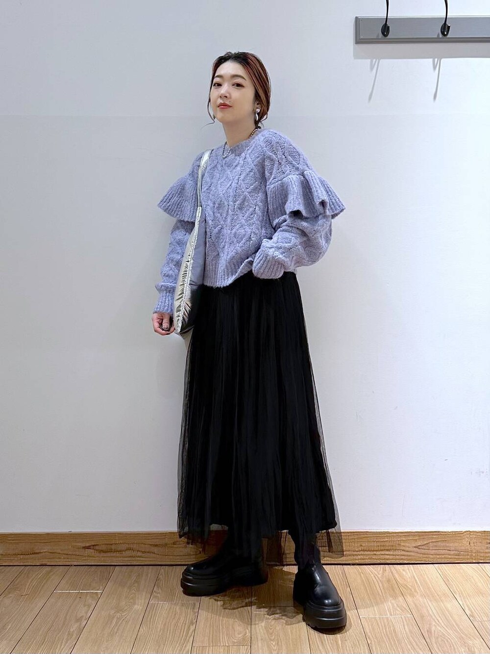 シルバー系のトートバッグ、パープル系のニット/セーター、ブラック系のブーツを着用したレディースの冬コーディネートの9枚目の写真