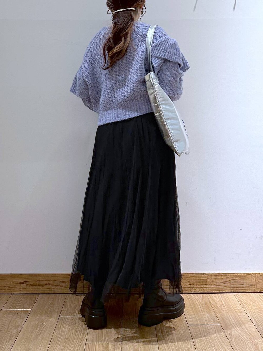 シルバー系のトートバッグ、パープル系のニット/セーター、ブラック系のブーツを着用したレディースの冬コーディネートの6枚目の写真