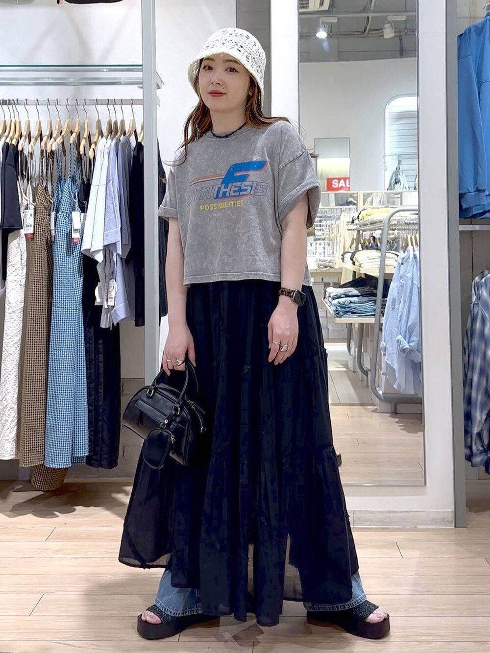 ブラック系のサンダル、ブラック系のスカート、グレー系のTシャツ/カットソーを着用したレディースの春コーディネートの2枚目の写真