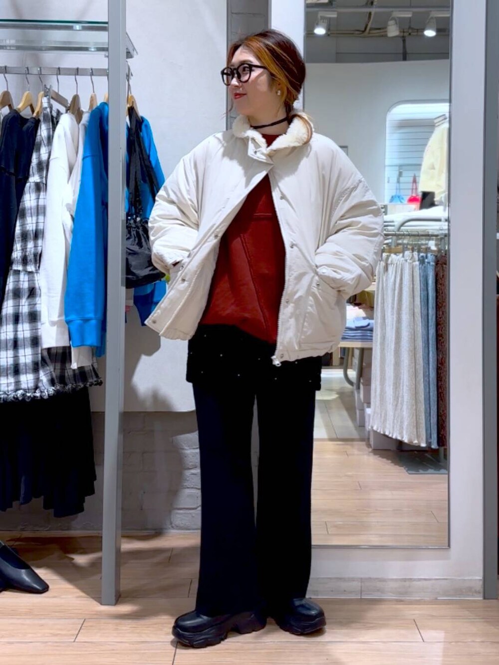 ブラック系のブーツ、ホワイト系のブルゾン、ブラック系のその他パンツを着用したレディースの冬コーディネートの2枚目の写真