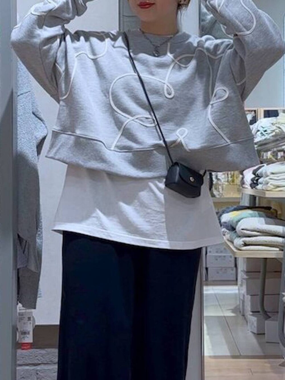 ブラック系のスカート、ブラック系のショルダーバッグ、シルバー系のスニーカーを着用したレディースの冬コーディネートの7枚目の写真