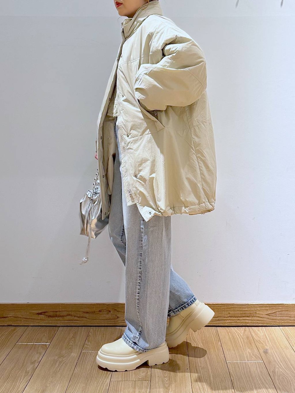 ホワイト系のダウンジャケット/コート、ブルー系のデニムパンツ、ホワイト系のブーツを着用したレディースの冬コーディネートの3枚目の写真