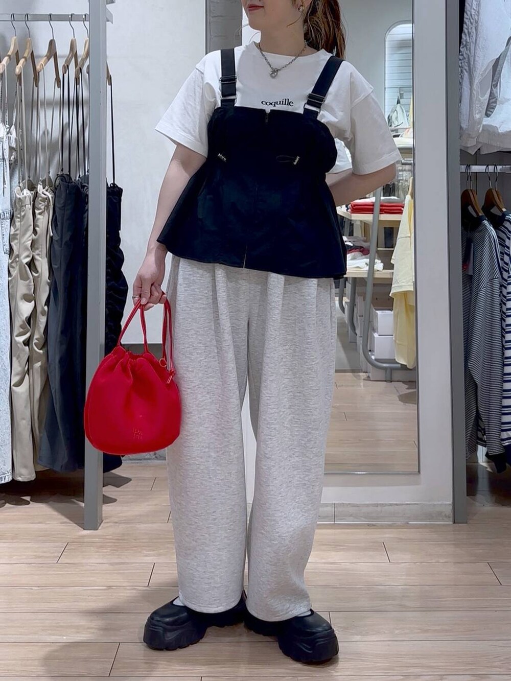 ブラック系のスニーカー、ホワイト系のTシャツ/カットソー、ブラック系のベストを着用したレディースの春コーディネートの2枚目の写真