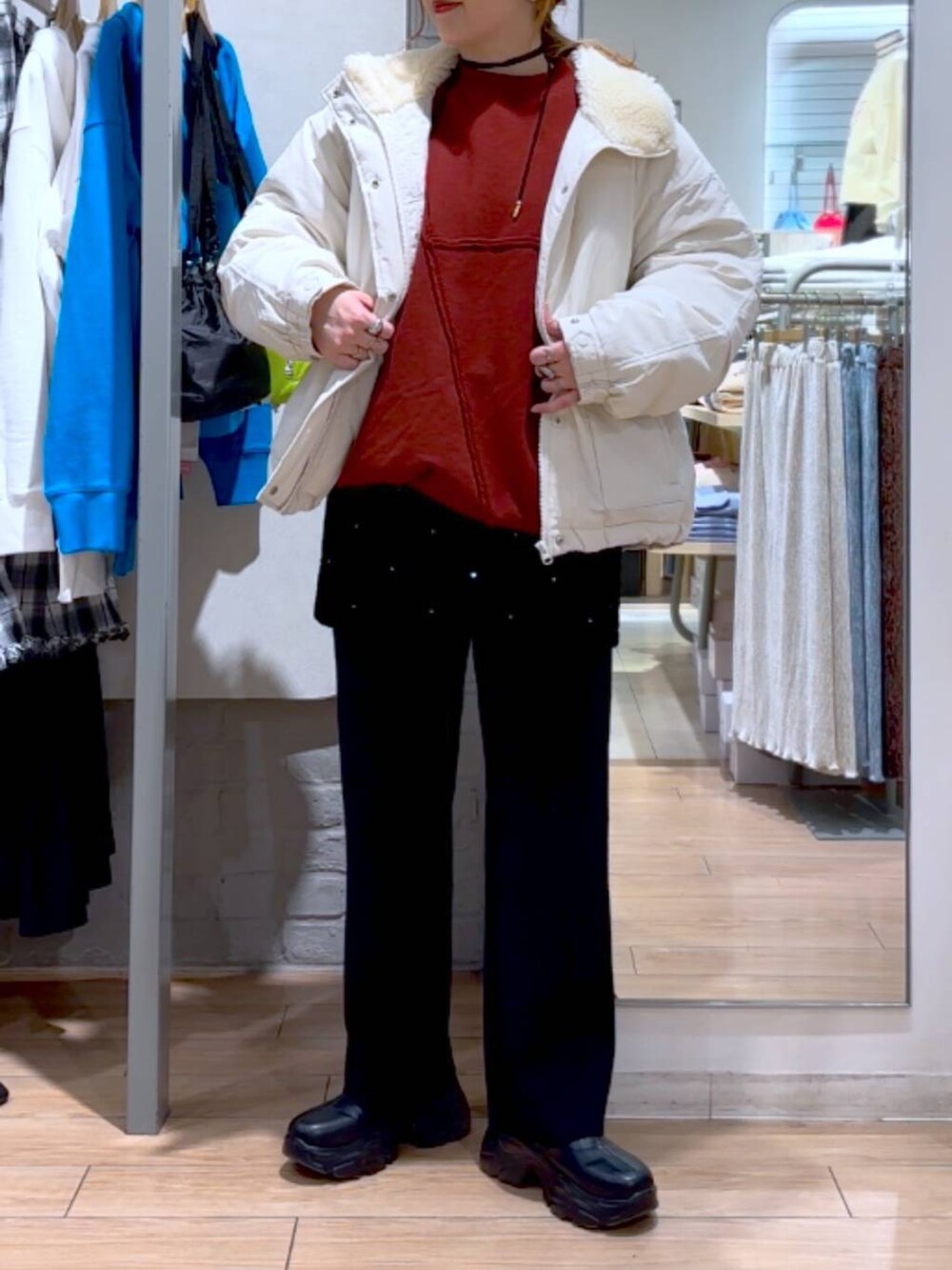 ブラック系のブーツ、ホワイト系のブルゾン、ブラック系のその他パンツを着用したレディースの冬コーディネートの3枚目の写真