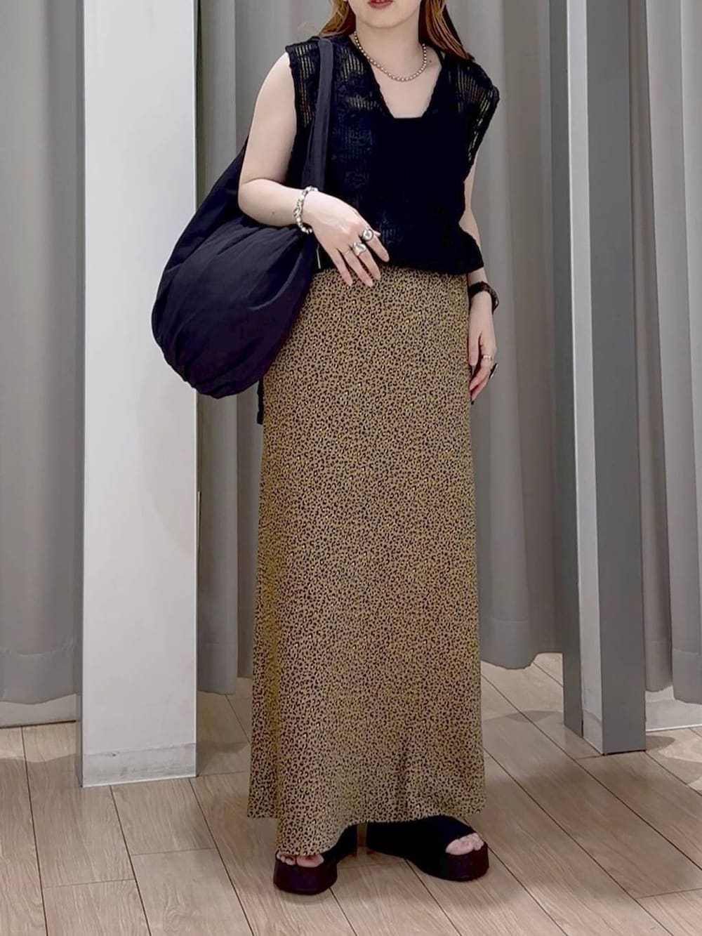 ブラック系のサンダル、ブラック系のトートバッグ、その他のスカートを着用したレディースの秋コーディネートの6枚目の写真