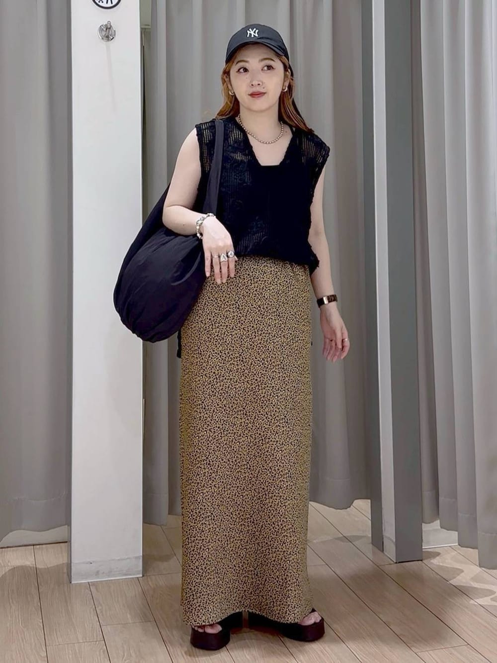 ブラック系のサンダル、ブラック系のトートバッグ、その他のスカートを着用したレディースの秋コーディネートの5枚目の写真