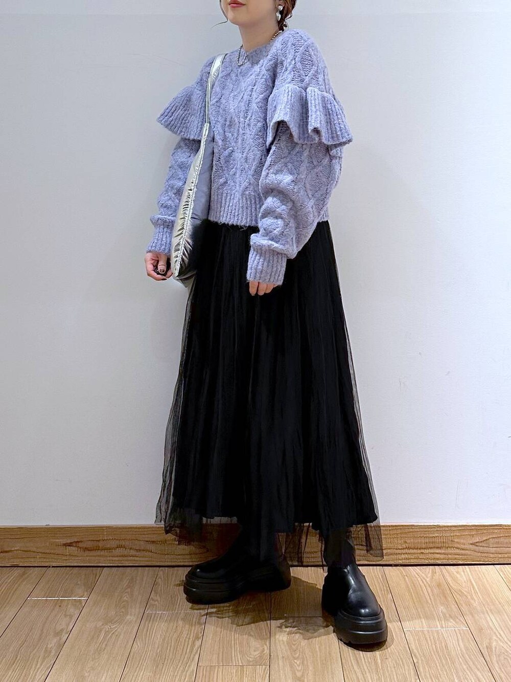 シルバー系のトートバッグ、パープル系のニット/セーター、ブラック系のブーツを着用したレディースの冬コーディネートの2枚目の写真