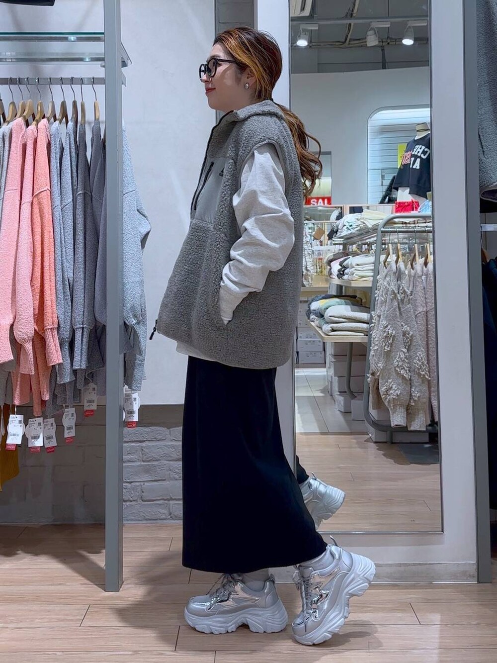 ブラック系のスカート、ブラック系のショルダーバッグ、シルバー系のスニーカーを着用したレディースの冬コーディネートの3枚目の写真