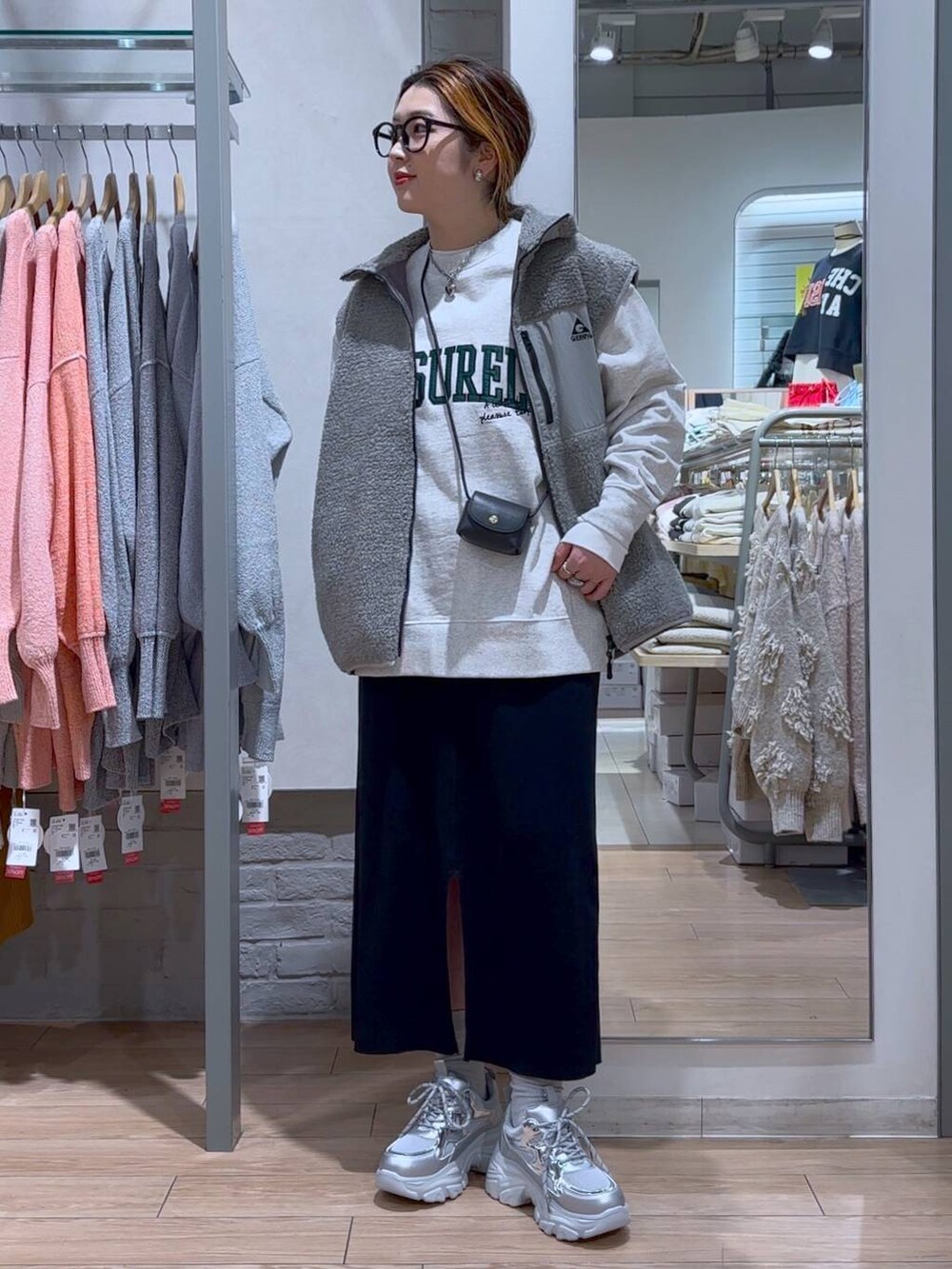 ブラック系のスカート、ブラック系のショルダーバッグ、シルバー系のスニーカーを着用したレディースの冬コーディネートの8枚目の写真