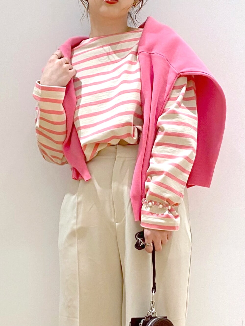 ピンク系のカーディガン/ボレロ、ピンク系のTシャツ/カットソー、ホワイト系のその他パンツを着用したレディースの春コーディネートの2枚目の写真