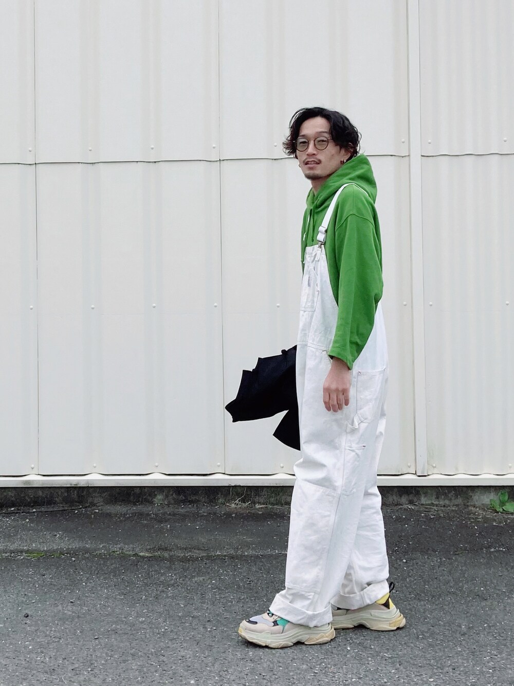 グリーン系のスニーカー、ブラック系のカバーオール、グリーン系のパーカーを着用したメンズの冬コーディネートの3枚目の写真