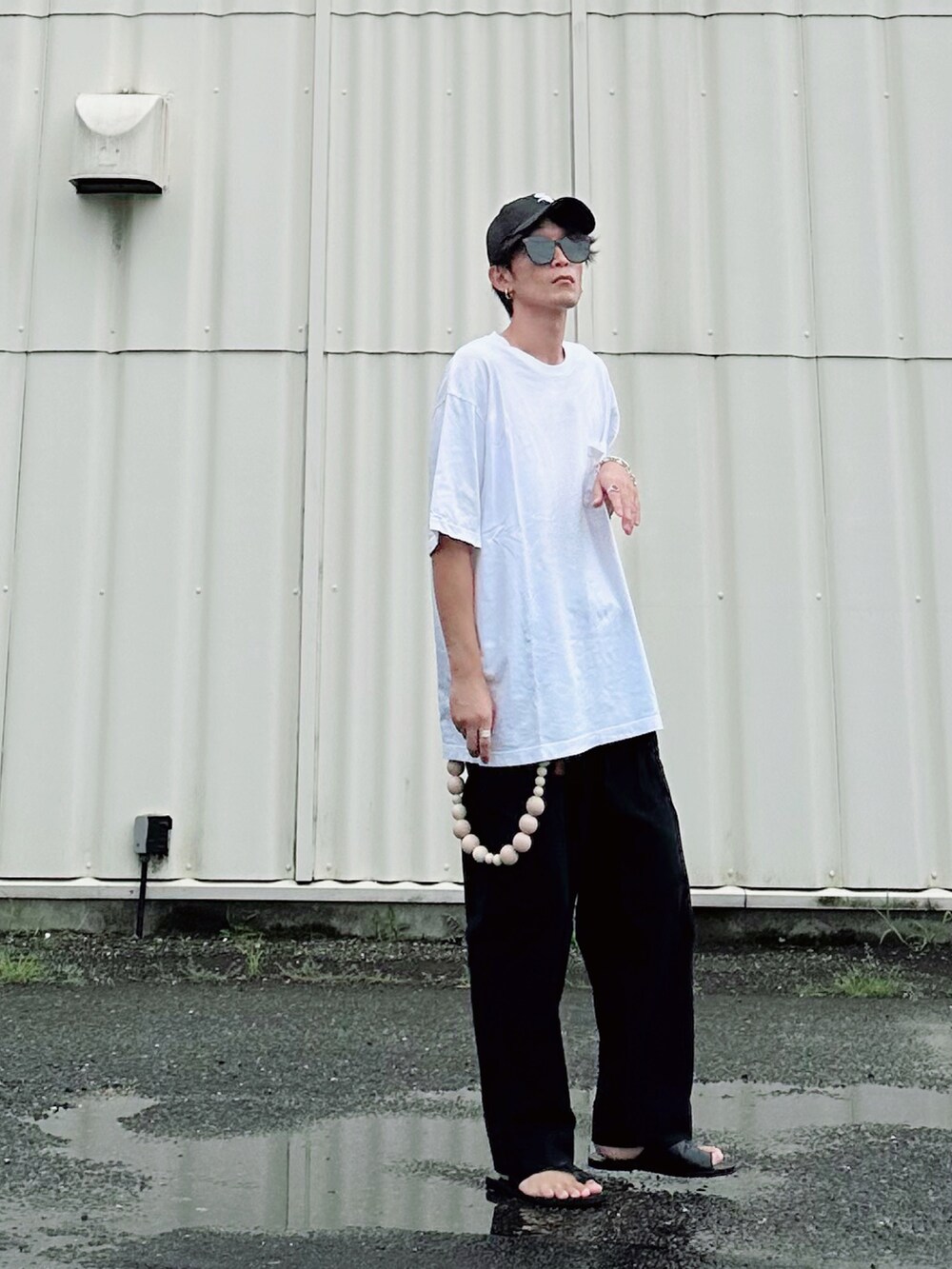 ブラック系のサンダル、ホワイト系のTシャツ/カットソー、ブラック系のサングラスを着用したメンズの夏コーディネートの2枚目の写真