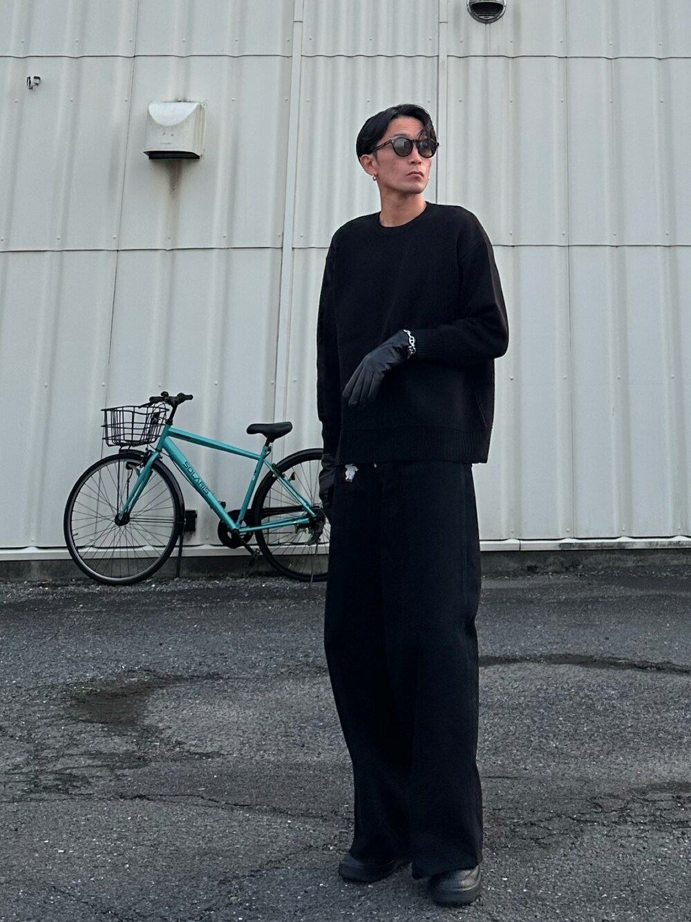 ブラック系のデニムパンツ、ブラック系のスニーカー、ブラック系の手袋を着用したメンズの冬コーディネートの2枚目の写真