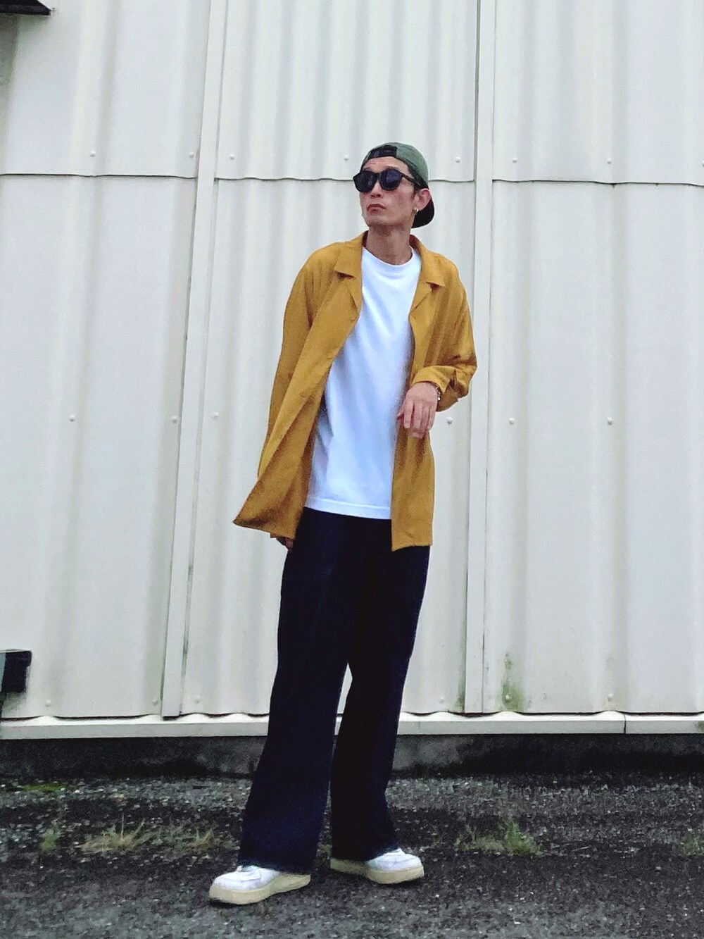 ブルー系のデニムパンツ、ホワイト系のスニーカー、イエロー系のシャツ/ブラウスを着用したメンズの秋コーディネートの2枚目の写真