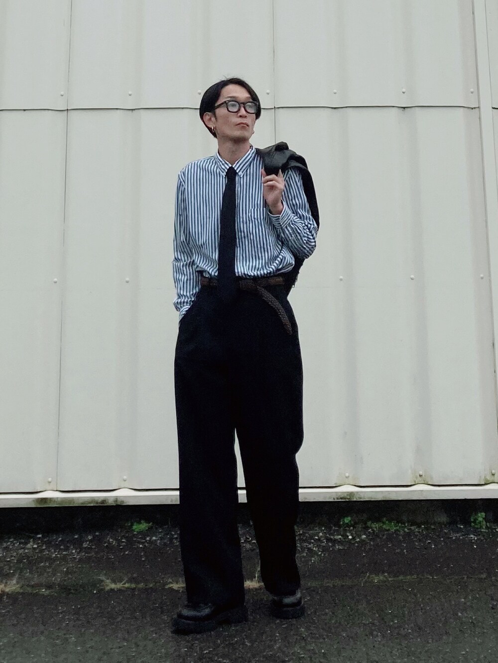 ブラック系のスラックス、ブラック系のブーツ、グリーン系のシャツ/ブラウスを着用したメンズの冬コーディネートの3枚目の写真