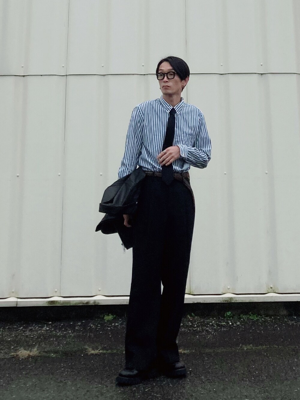 ブラック系のスラックス、ブラック系のブーツ、グリーン系のシャツ/ブラウスを着用したメンズの冬コーディネートの2枚目の写真