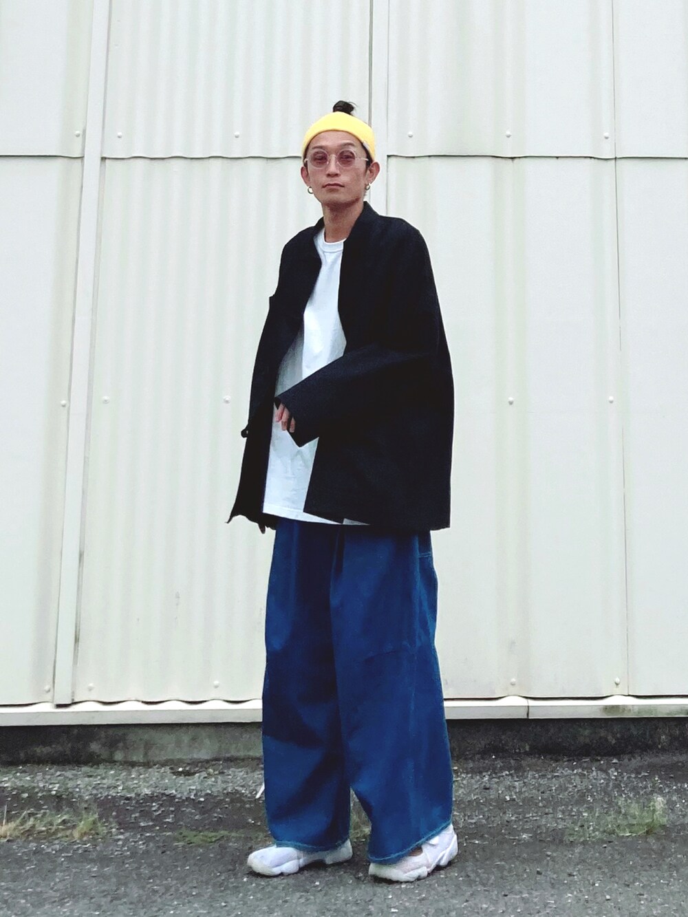 ブラック系のカバーオール、ブルー系のデニムパンツ、ホワイト系のサンダルを着用したメンズの秋コーディネートの2枚目の写真