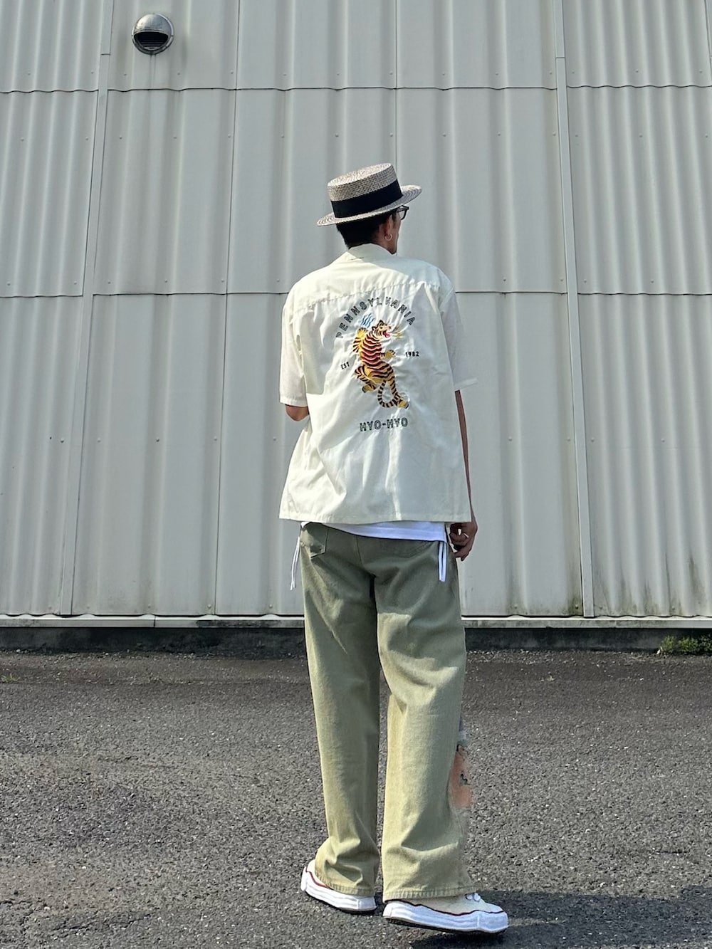 ホワイト系のタンクトップ、ホワイト系のスニーカー、パープル系のサングラスを着用したメンズの夏コーディネートの2枚目の写真