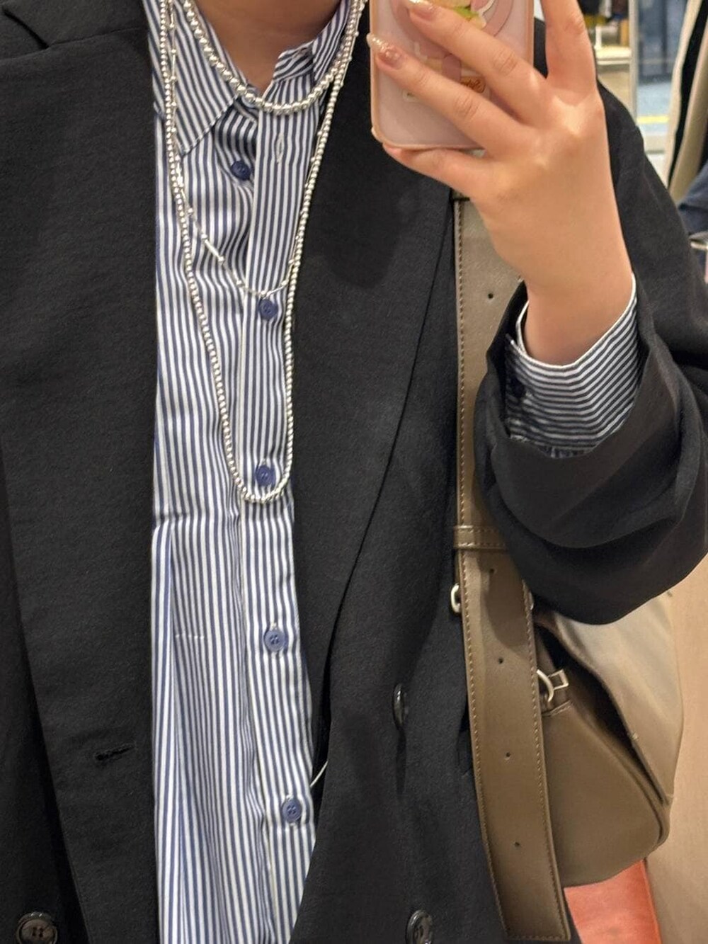 ブラウン系のショルダーバッグ、ホワイト系のパンプス、ブルー系のシャツ/ブラウスを着用したレディースの春コーディネートの4枚目の写真