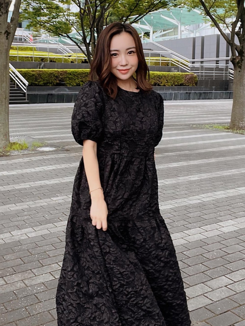 ブラック系のワンピース、ブラック系のサンダル、ブラウン系のかごバッグを着用したレディースの夏コーディネートの2枚目の写真