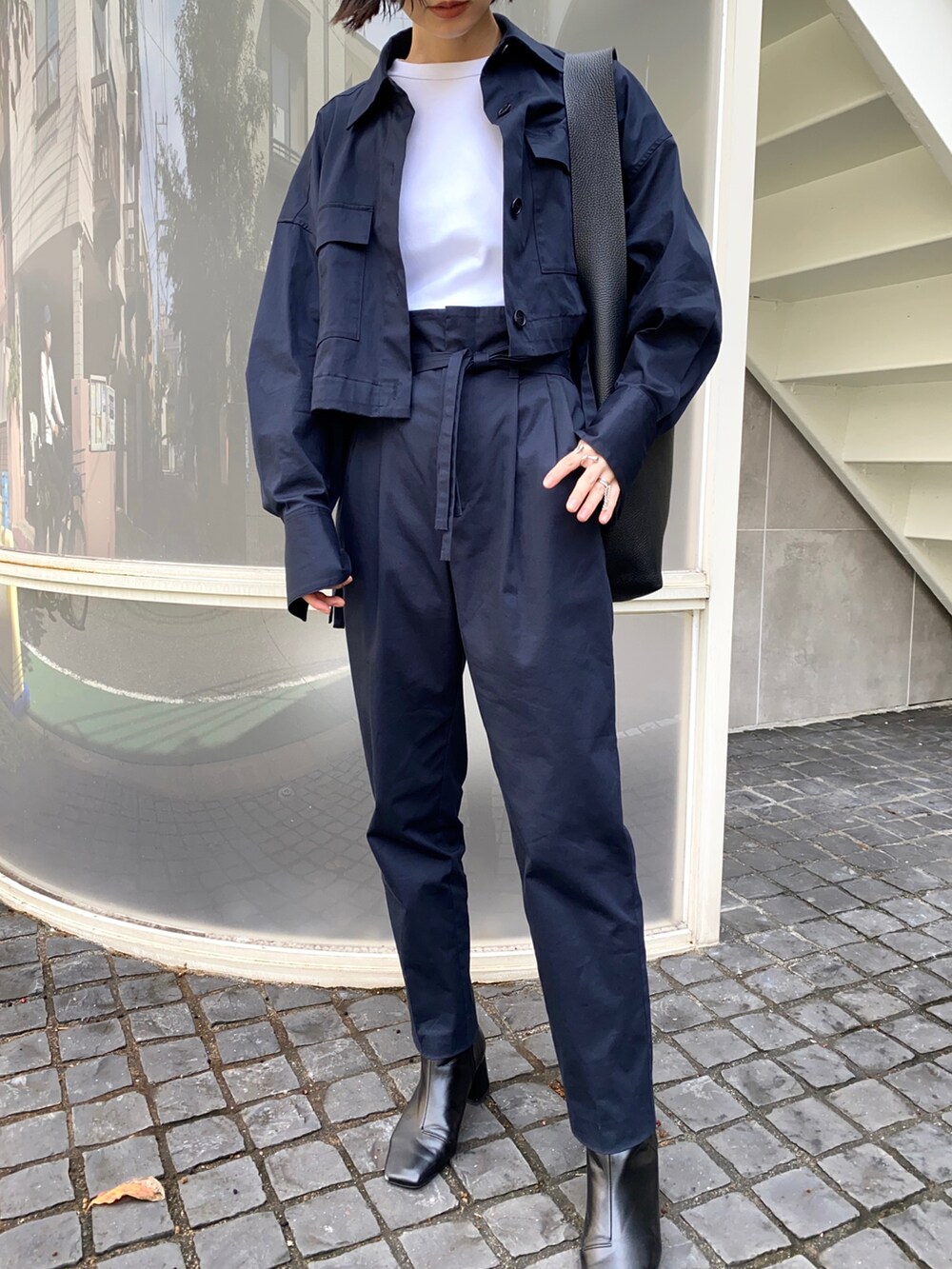 ブルー系のブルゾン、ブルー系のその他パンツ、ブラック系のトートバッグを着用したレディースの秋コーディネートの2枚目の写真