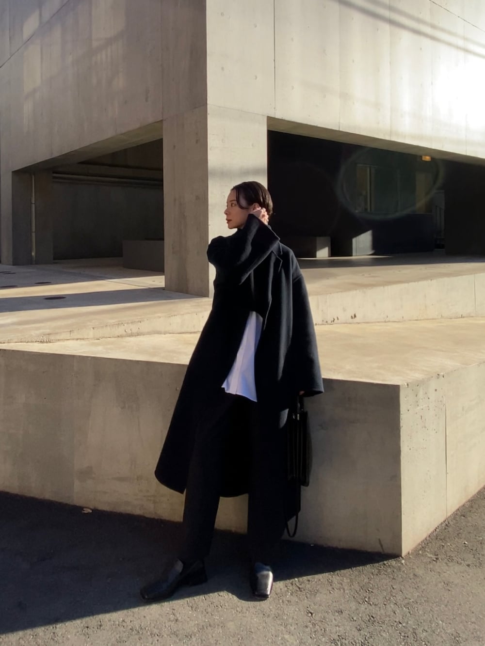 ブラック系のスラックス、ブラック系のローファーを着用したレディースの冬コーディネートの2枚目の写真