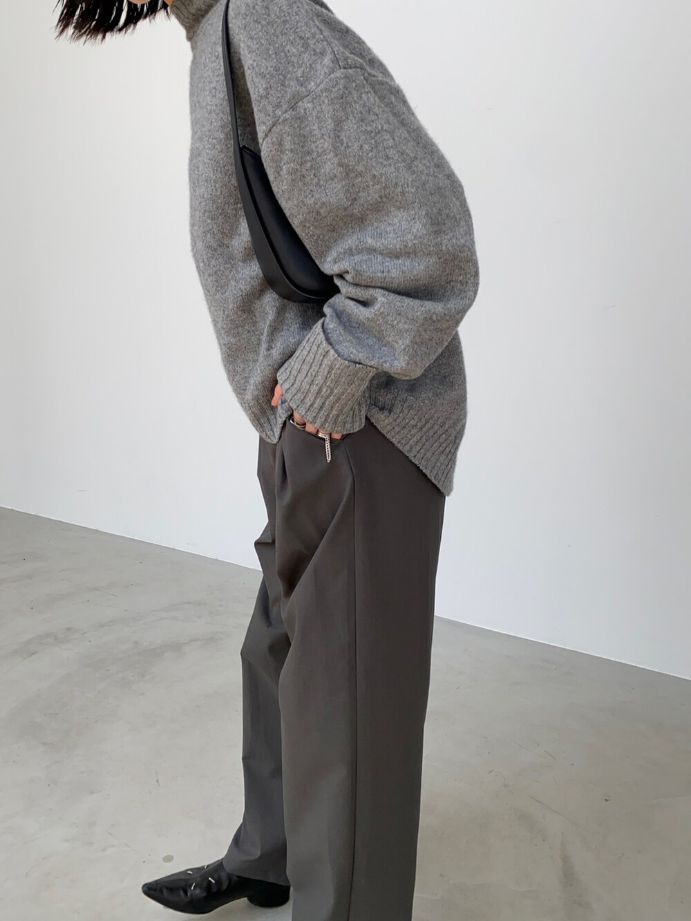 グレー系のスラックス、ブラック系のバックパック/リュックを着用したレディースの秋コーディネートの3枚目の写真