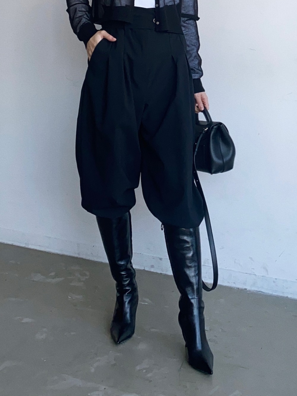 ブラック系のスラックス、ブラック系のニット/セーターを着用したレディースの秋コーディネートの4枚目の写真