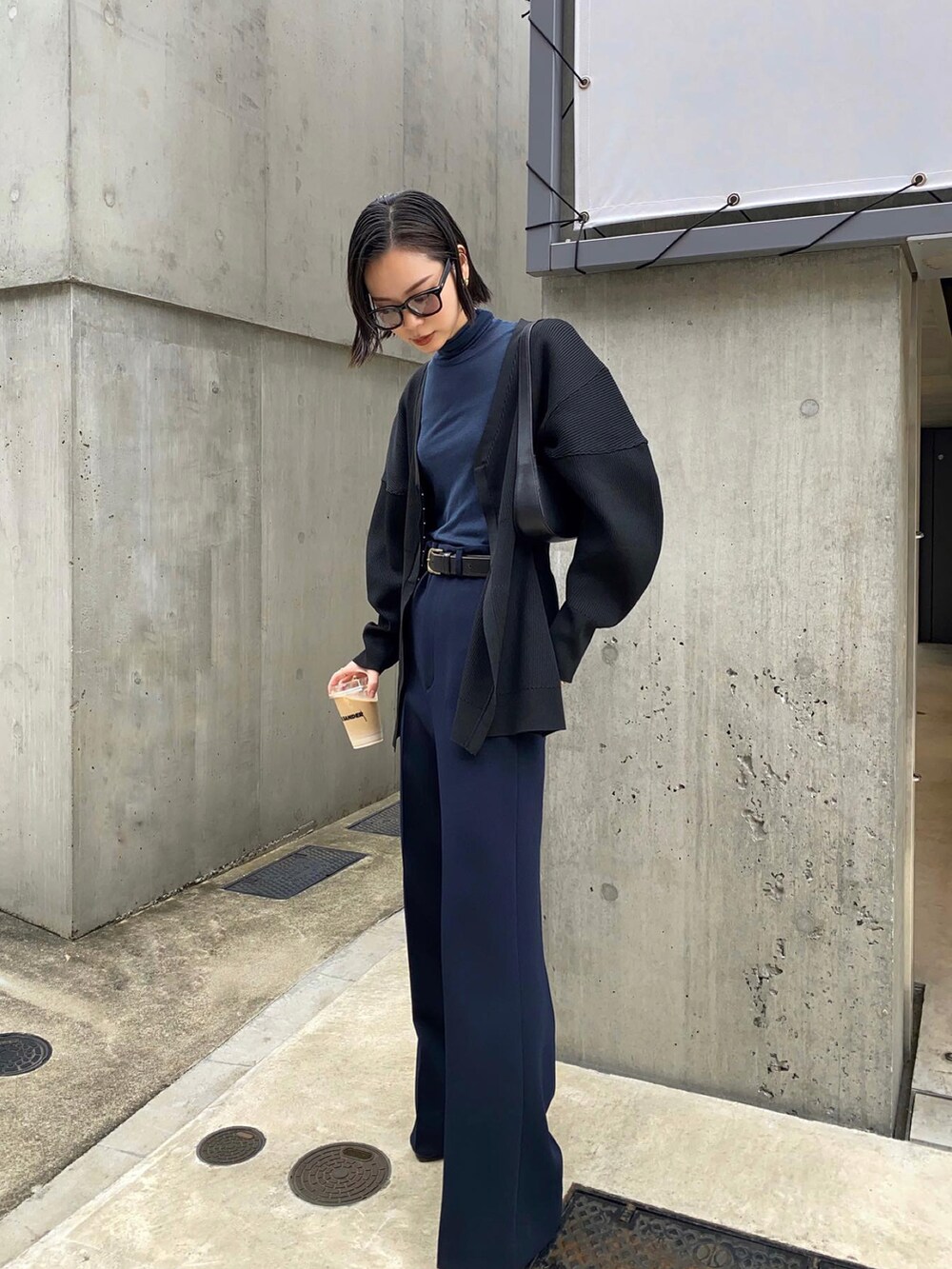 ブラック系のカーディガン/ボレロ、ブルー系のトップス、ブルー系のパンツを着用したレディースの秋コーディネートの4枚目の写真