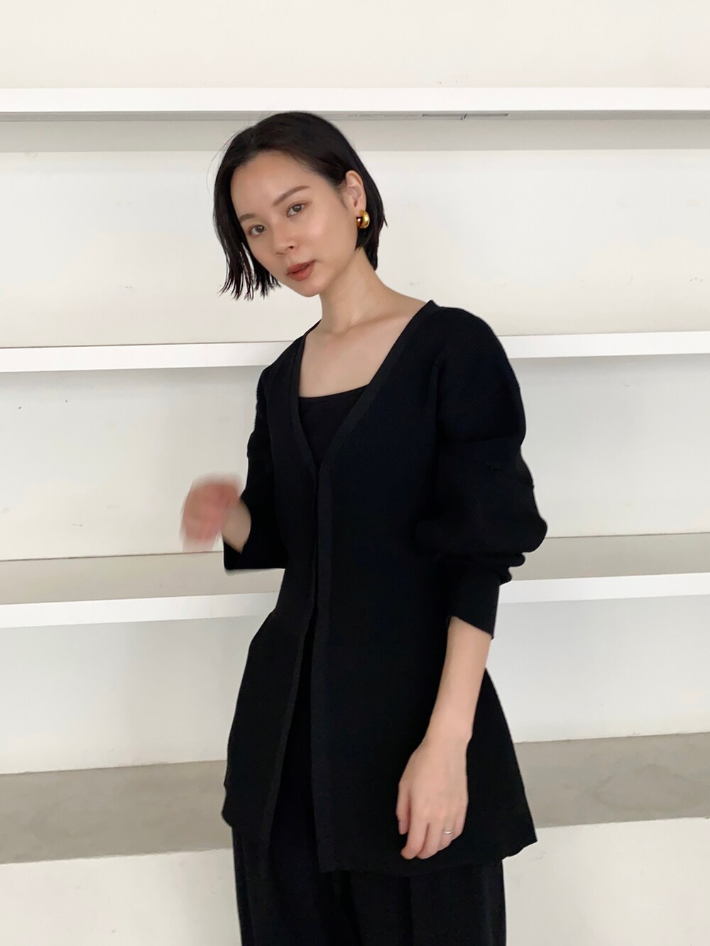 ブラック系のサンダル、ブラック系のカーディガン/ボレロを着用したレディースの春コーディネートの2枚目の写真