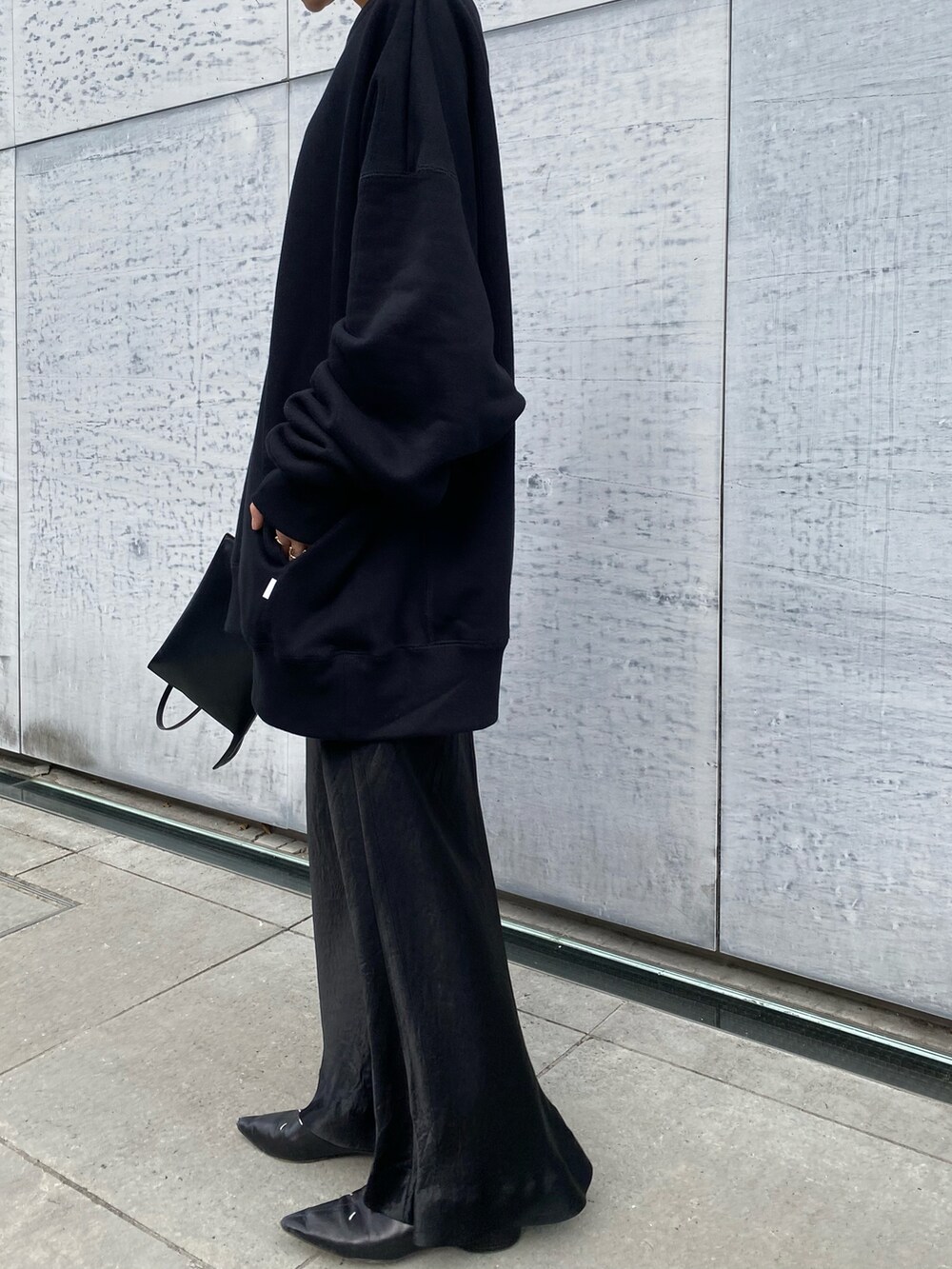 ブラック系のスカート、ブラック系のブーツ、ブラック系のショルダーバッグを着用したレディースの秋コーディネートの2枚目の写真