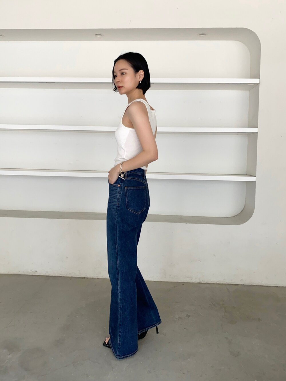 ブルー系のデニムパンツ、ブラック系のサンダルを着用したレディースの春コーディネートの2枚目の写真