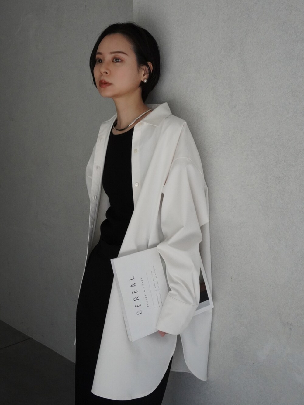 ブラック系のスラックス、ホワイト系のシャツ/ブラウス、ブラック系のサンダルを着用したレディースの春コーディネートの2枚目の写真