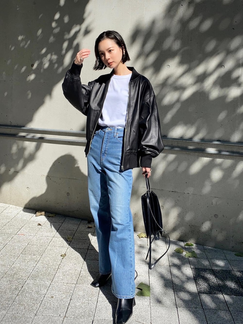 ブラック系のMA-1、ブルー系のデニムパンツを着用したレディースの秋コーディネートの2枚目の写真