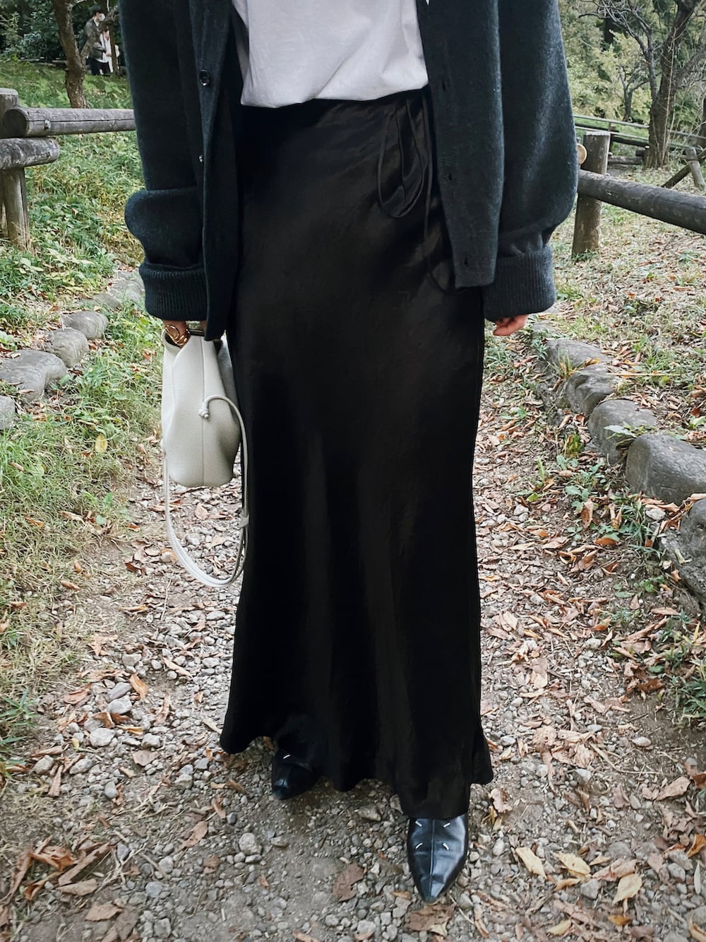 ブラック系のスカート、グレー系のカーディガン/ボレロ、ホワイト系のTシャツ/カットソーを着用したレディースの秋コーディネートの3枚目の写真