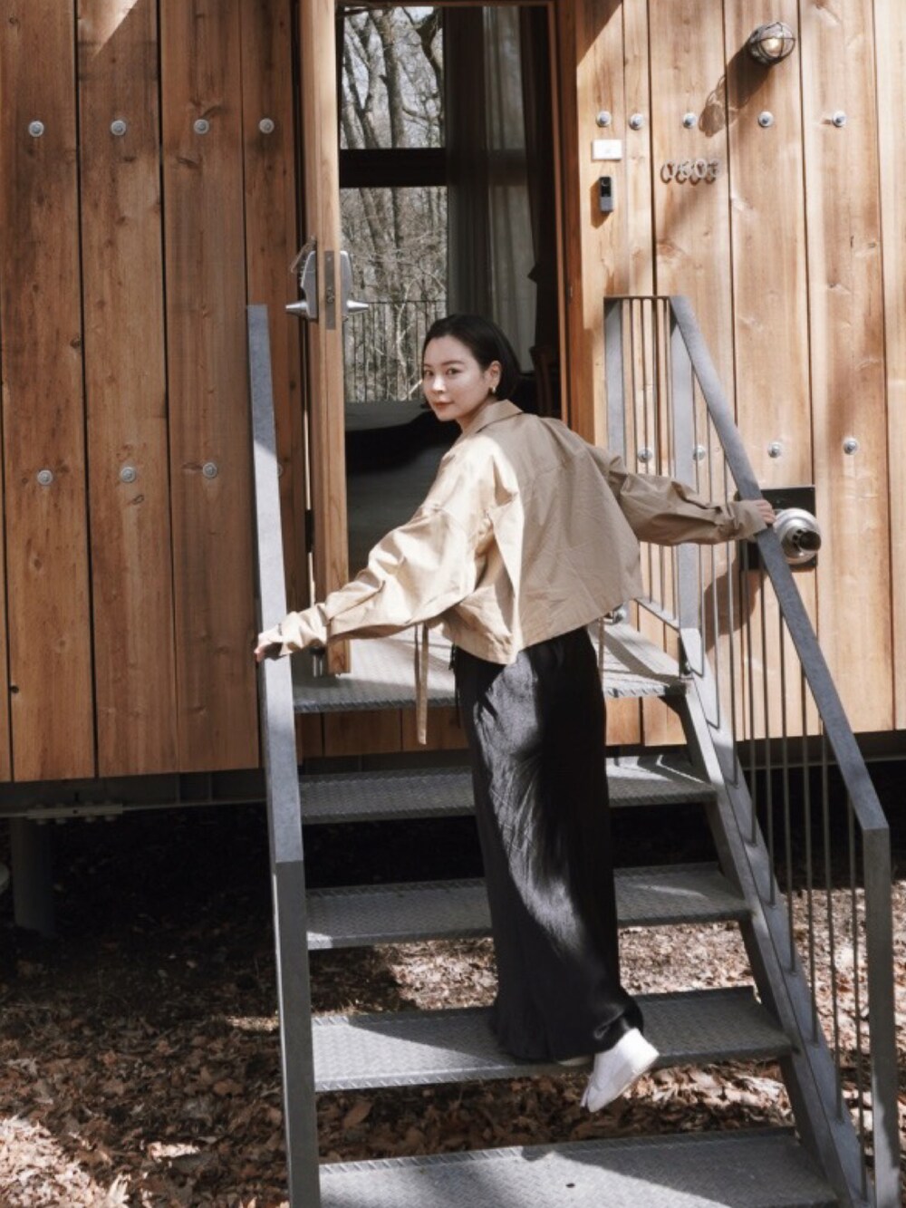 ベージュ系のブルゾン、ブラック系のスカートを着用したレディースの春コーディネートの2枚目の写真