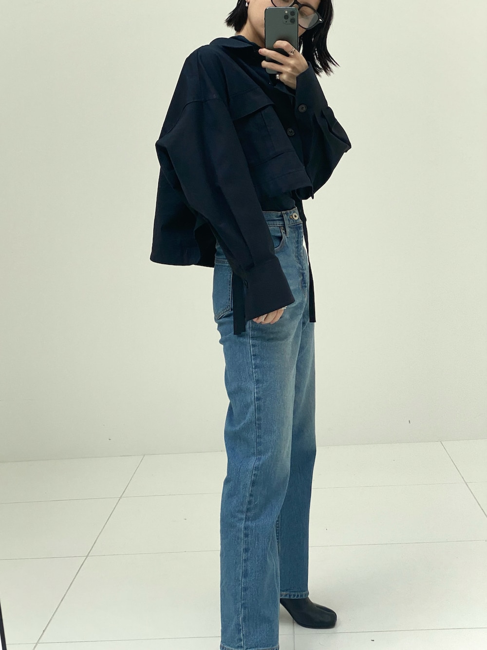 ブルー系のブルゾン、ブルー系のデニムパンツを着用したレディースの秋コーディネートの2枚目の写真