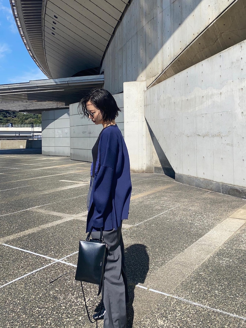 グレー系のその他パンツ、ブラック系のショルダーバッグ、ブルー系のカーディガン/ボレロを着用したレディースの秋コーディネートの5枚目の写真