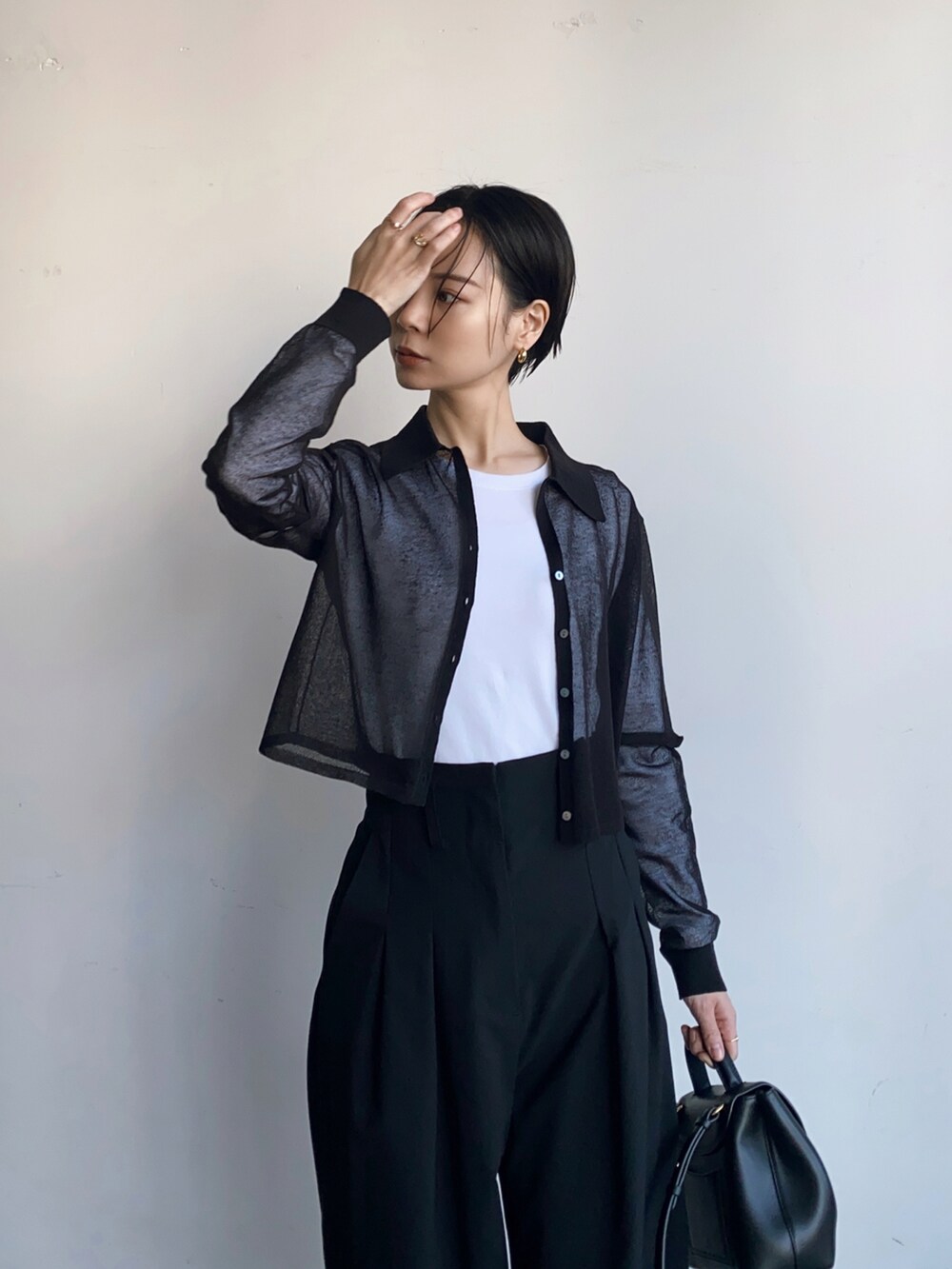 ブラック系のスラックス、ブラック系のニット/セーターを着用したレディースの秋コーディネートの3枚目の写真