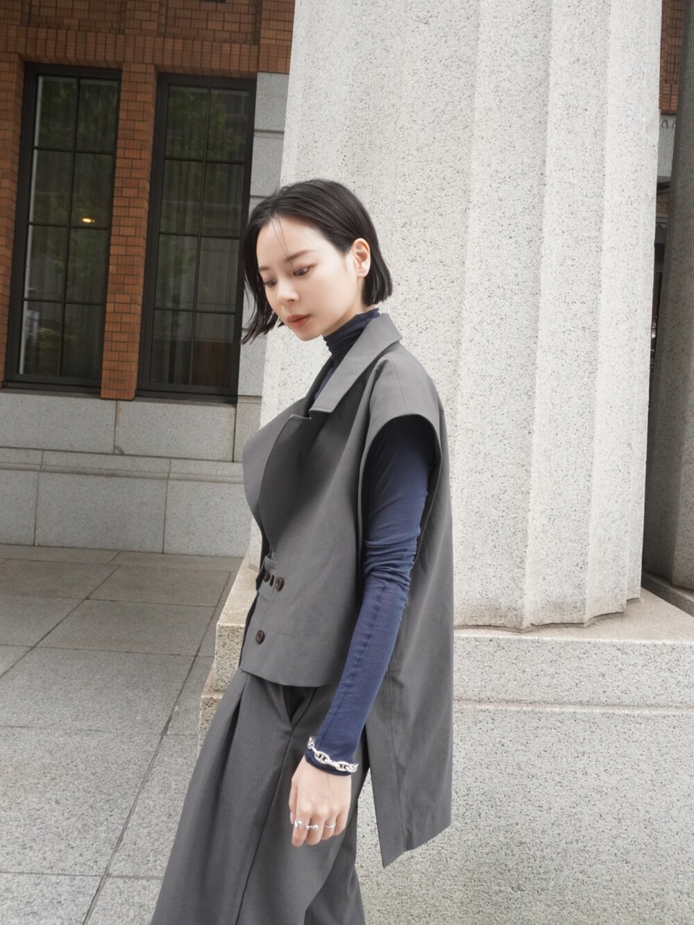 ブルー系のトップス、グレー系のベスト、グレー系のスラックスを着用したレディースの夏コーディネートの2枚目の写真