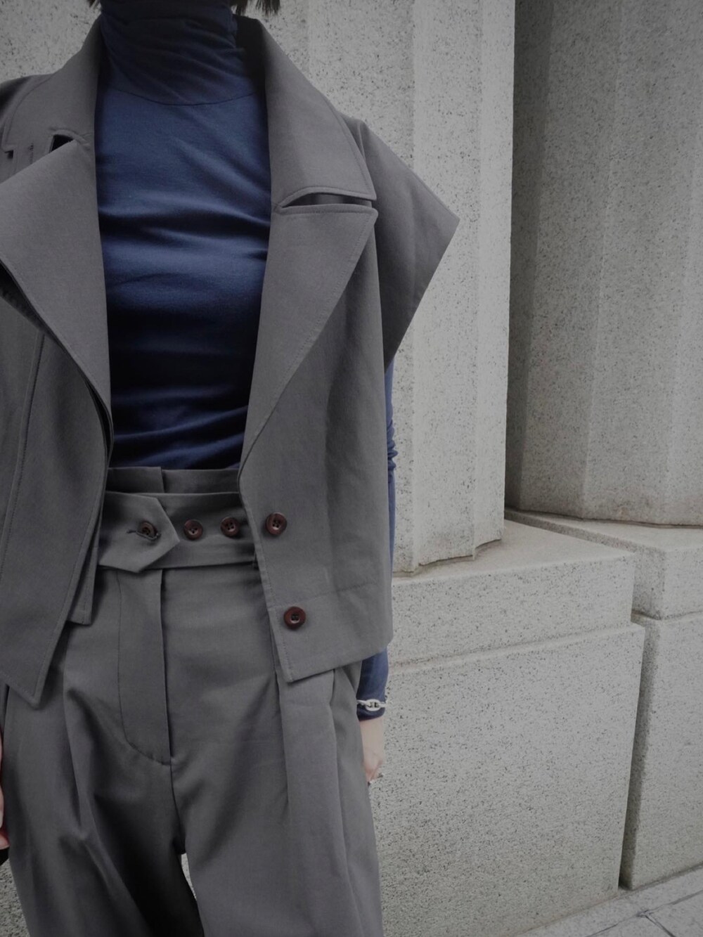 ブルー系のトップス、グレー系のスラックス、グレー系のベストを着用したレディースの夏コーディネートの4枚目の写真