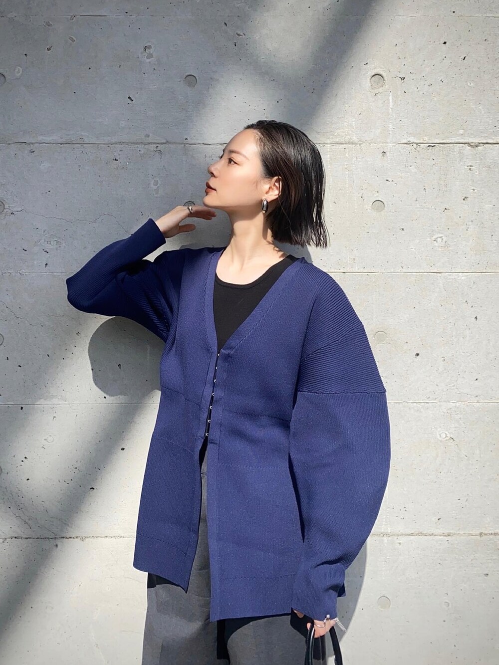 グレー系のその他パンツ、ブラック系のショルダーバッグ、ブルー系のカーディガン/ボレロを着用したレディースの秋コーディネートの4枚目の写真