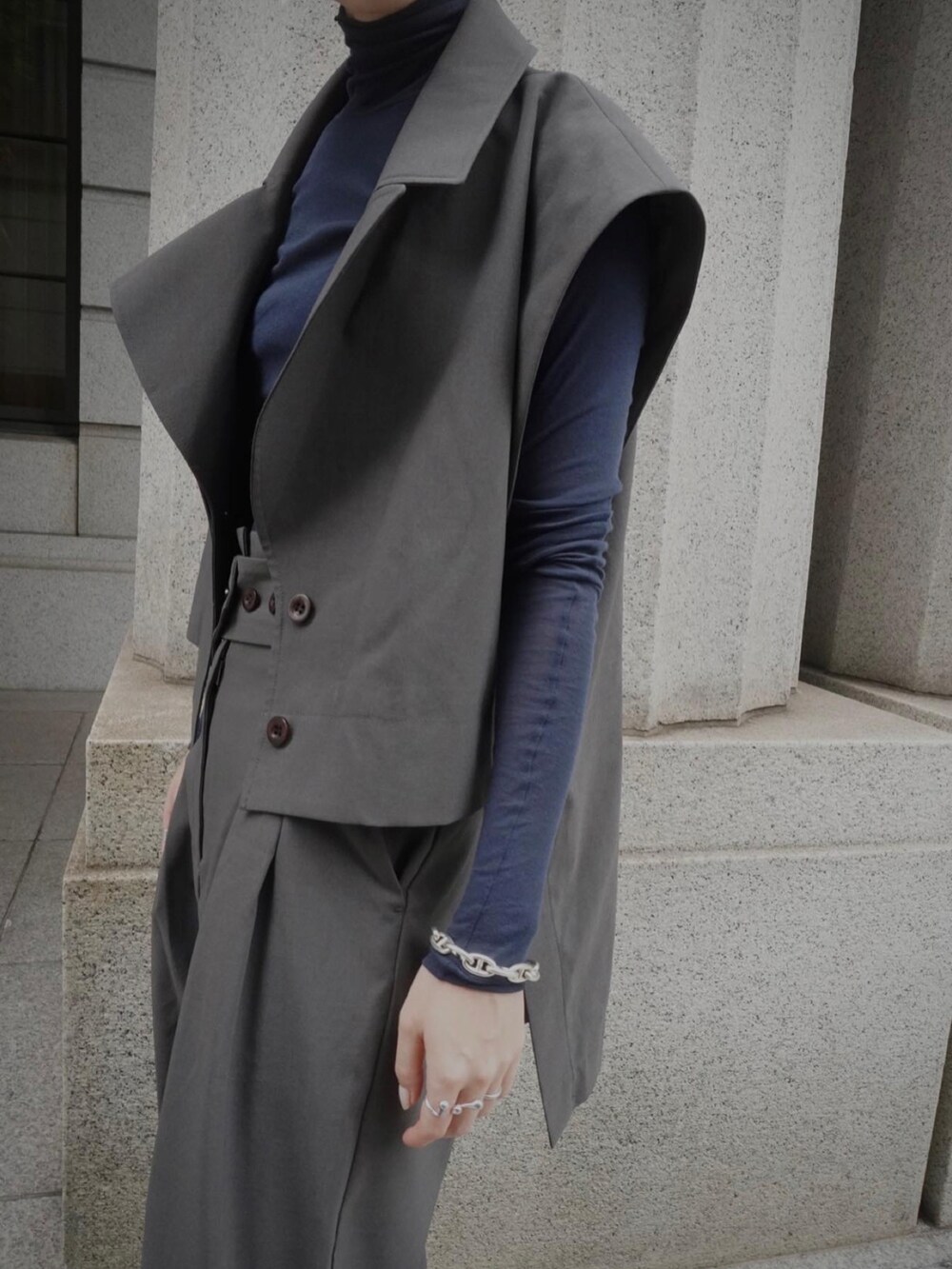 ブルー系のトップス、グレー系のスラックス、グレー系のベストを着用したレディースの夏コーディネートの5枚目の写真