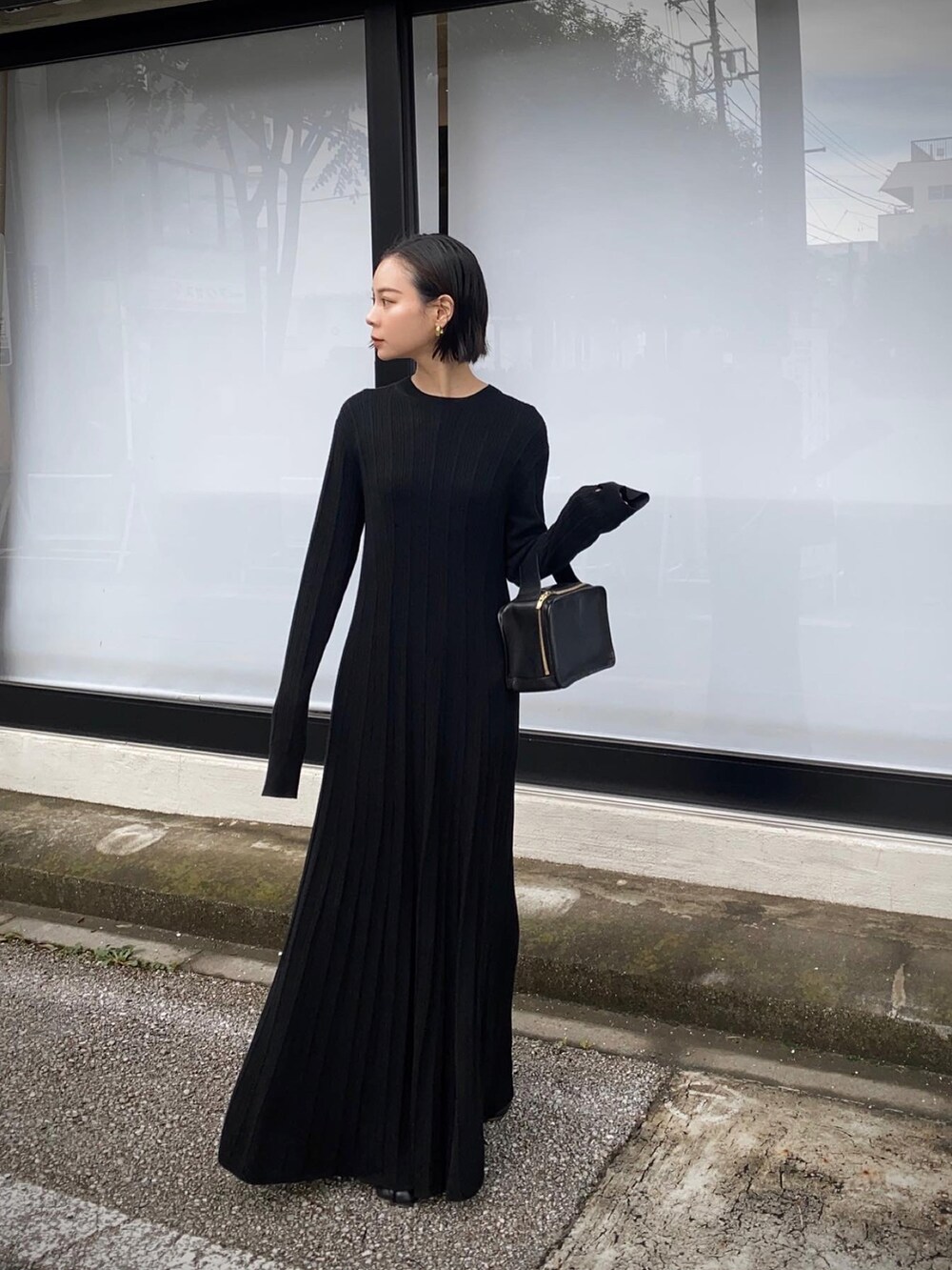 ブラック系のワンピース、ブラック系のハンドバッグを着用したレディースの秋コーディネートの3枚目の写真