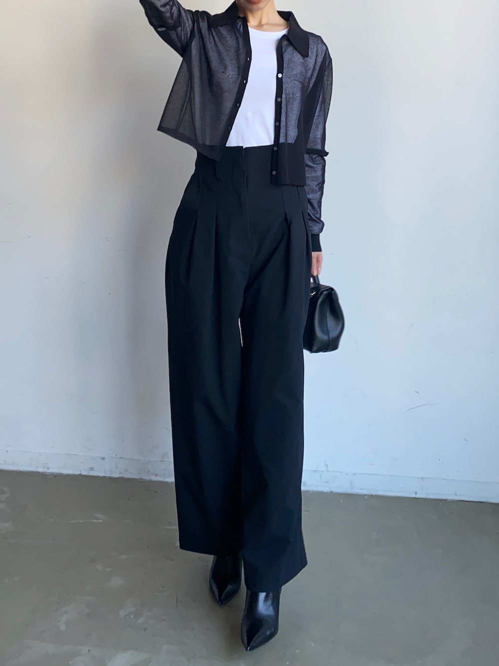 ブラック系のスラックス、ブラック系のニット/セーターを着用したレディースの秋コーディネートの5枚目の写真