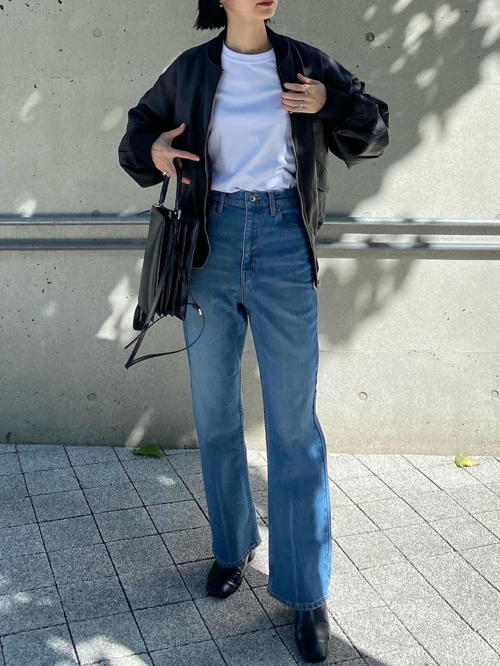 ブラック系のMA-1、ブルー系のデニムパンツを着用したレディースの秋コーディネートの3枚目の写真